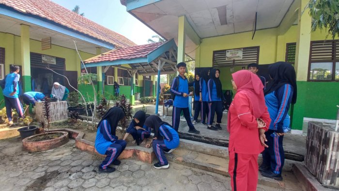 Kebersamaan di Kelas XI B : Ibu Deni Trizawati, S.Pd.I Pimpin Siswa Gotong Royong Bersihkan Ruang Kelas